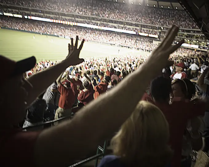 Baseball fans with outstretched arms, Angel Stadium of Anaheim, California.