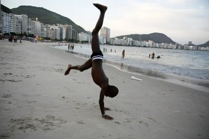 Kid doing acrobatics on Copacabana beach, Rio de Janeiro, Brazil.