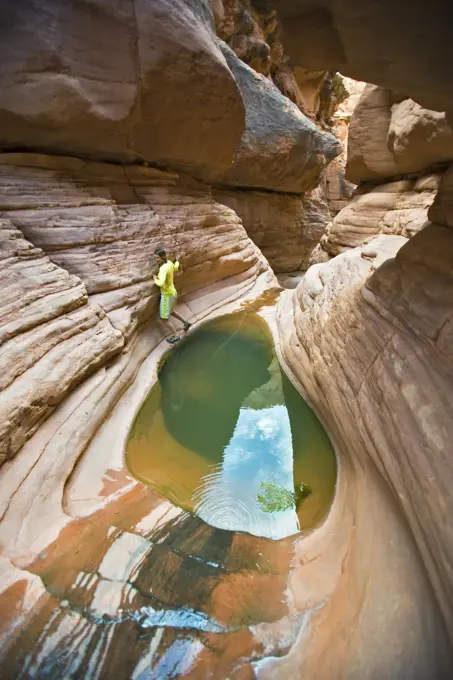 Woman in canyon going around a pool of water, Shinumo Canyon, Grand Canyon, Arizona.