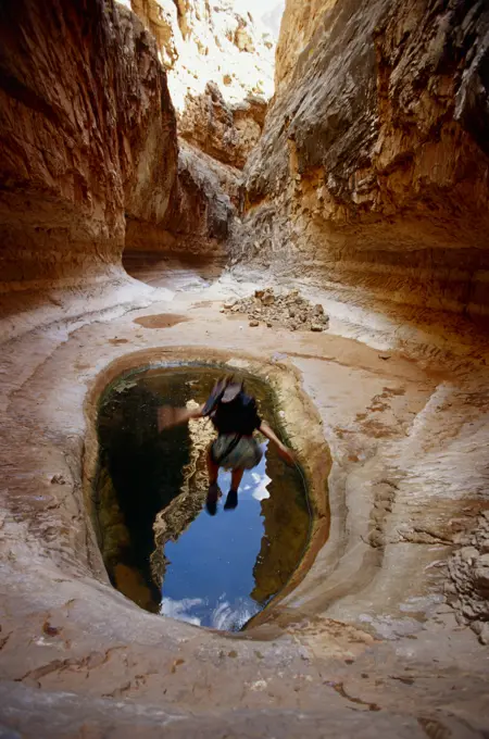 woman jumping into pool in desert canyon, Grand Canyon, Arizona