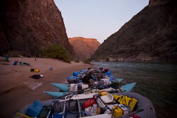 Man sitting with the rafts at camp in the Grand Canyon, Arizona.