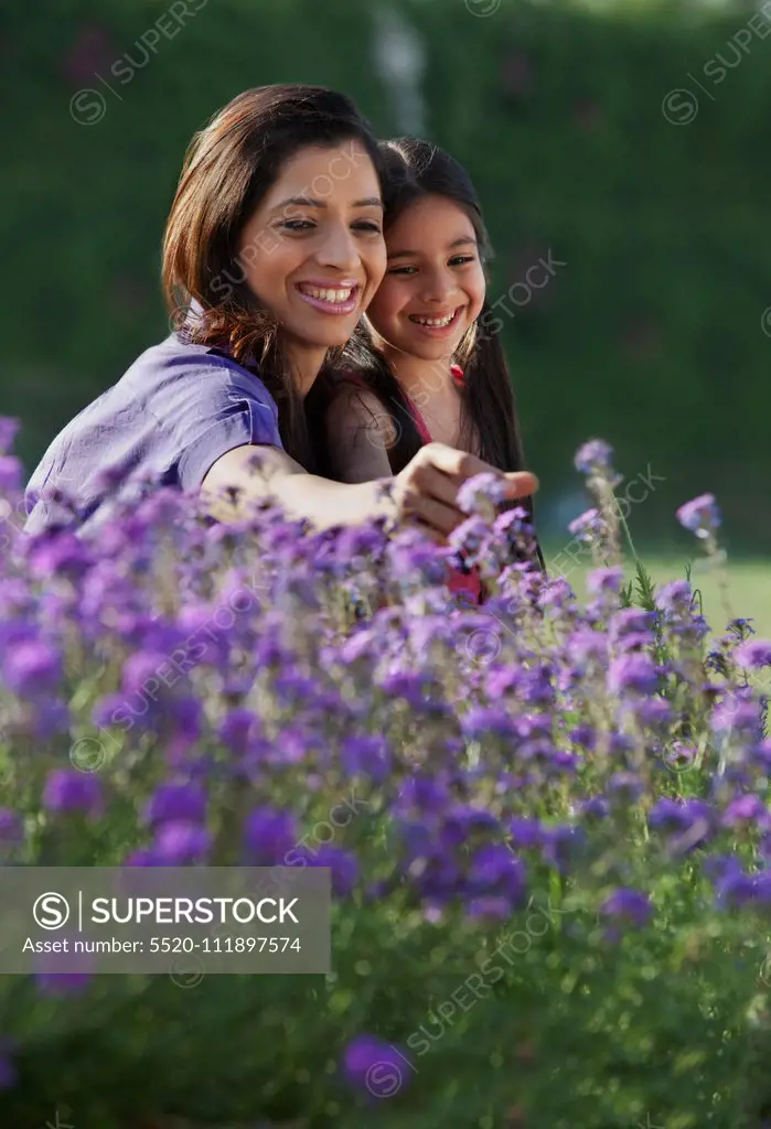 Mother and daughter plucking flowers