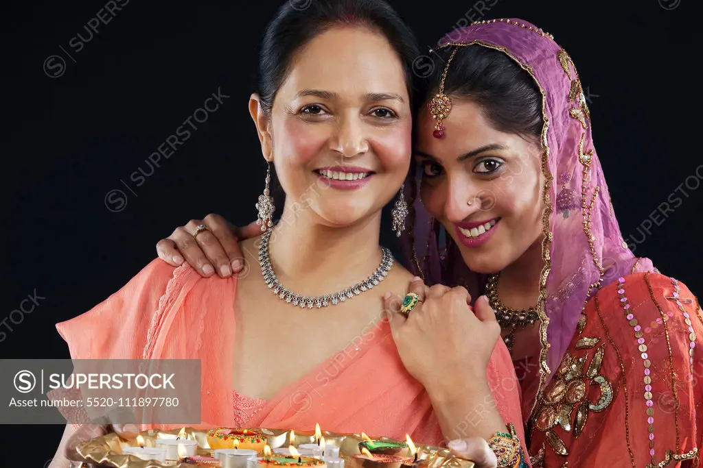 Mother and daughter with a tray of diyas