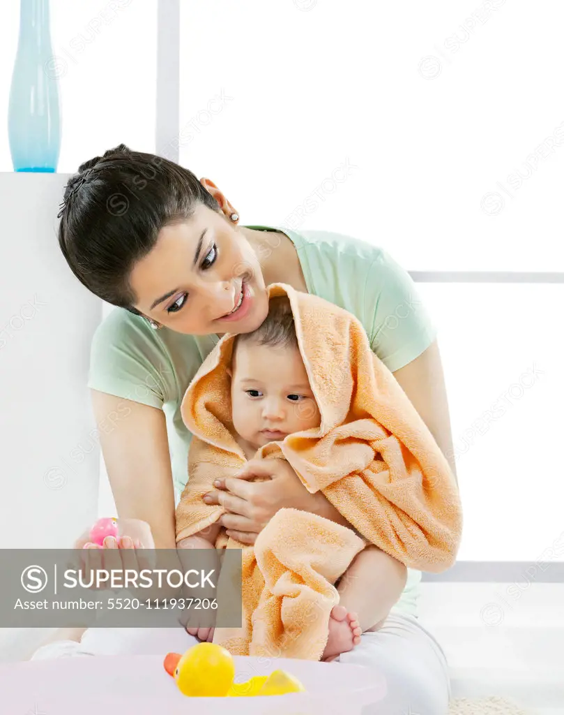 Mother and her baby looking at a rubber toy