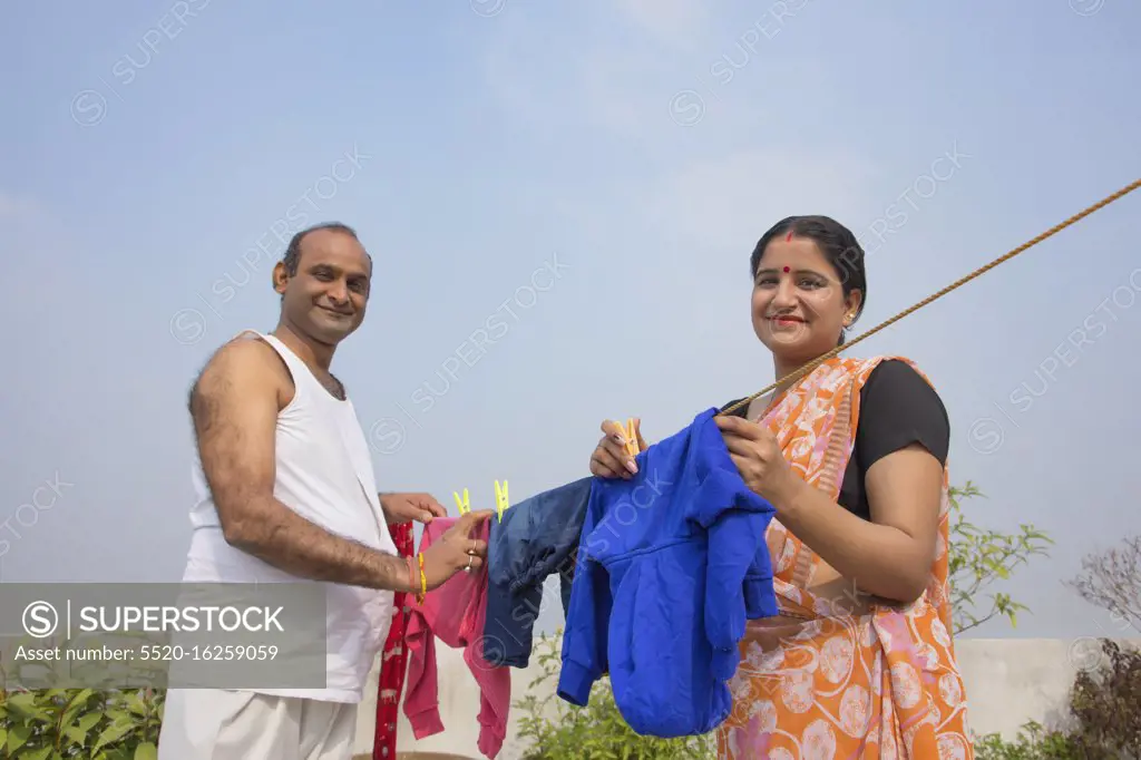 indian Couple drying clothes on clothesline