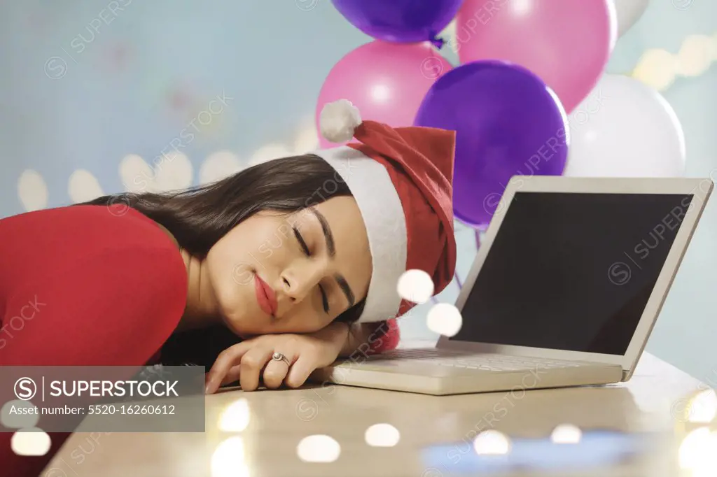 Young woman asleep on her desk after office party.