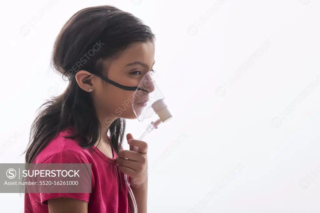 Young girl girl with asthma problems making inhalation with mask on her face. (Children)