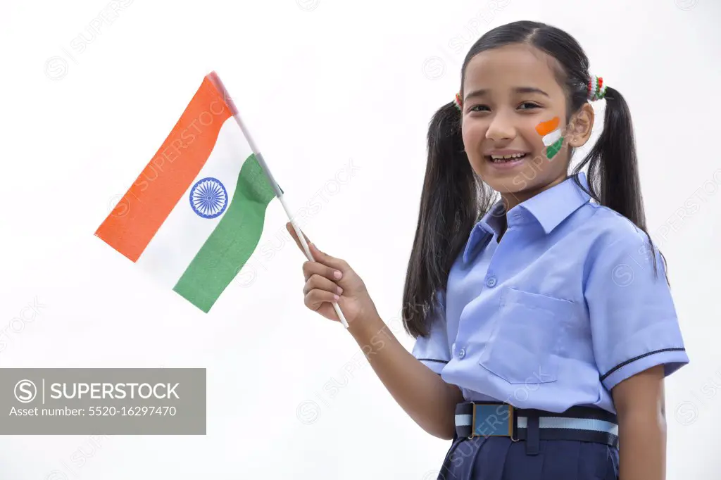 young school girl with flag drawn on her cheeks and holding flag in her hand , independence day