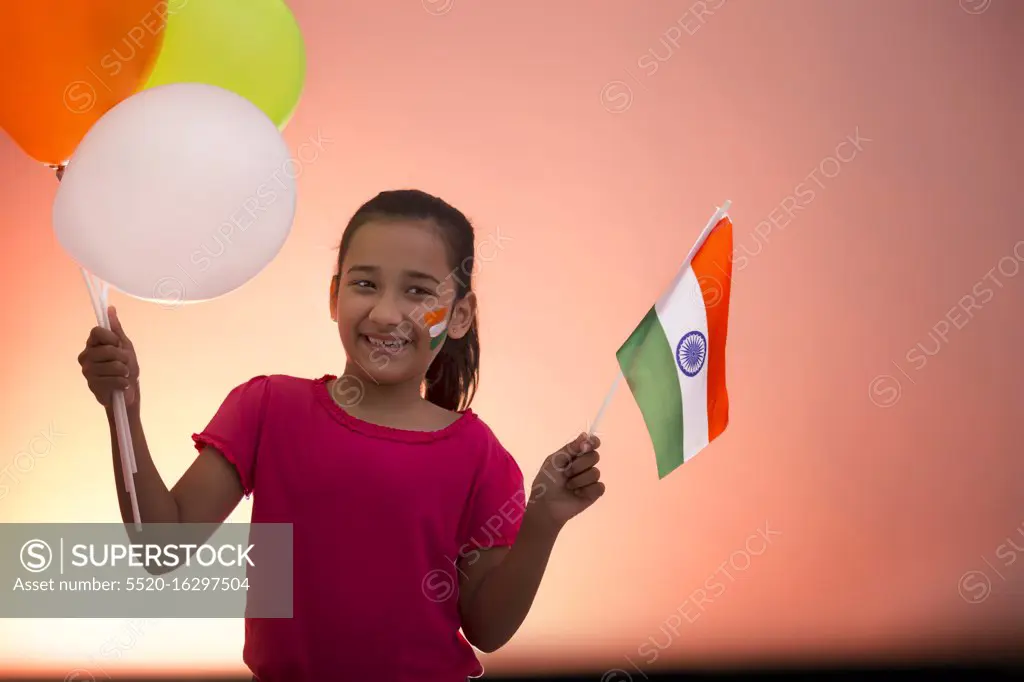 young girl holding flag and balloons, independence day