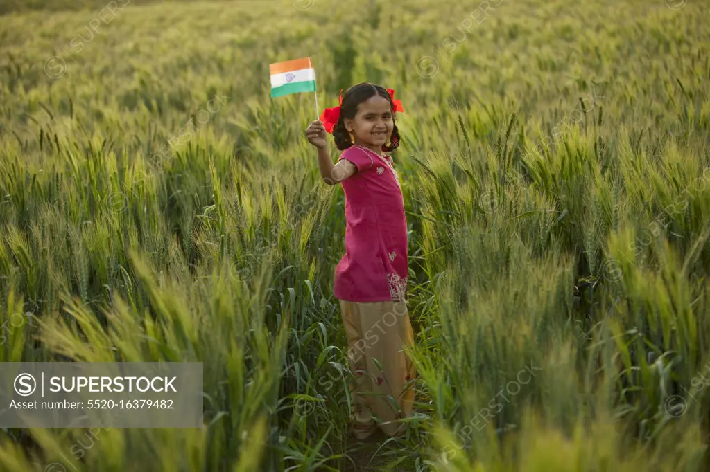 Portrait of a happy little girl holding an Indian flag