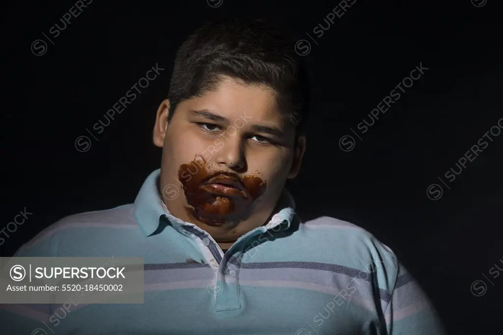 Young boy tired after having too much chocolates. (Obesity) 