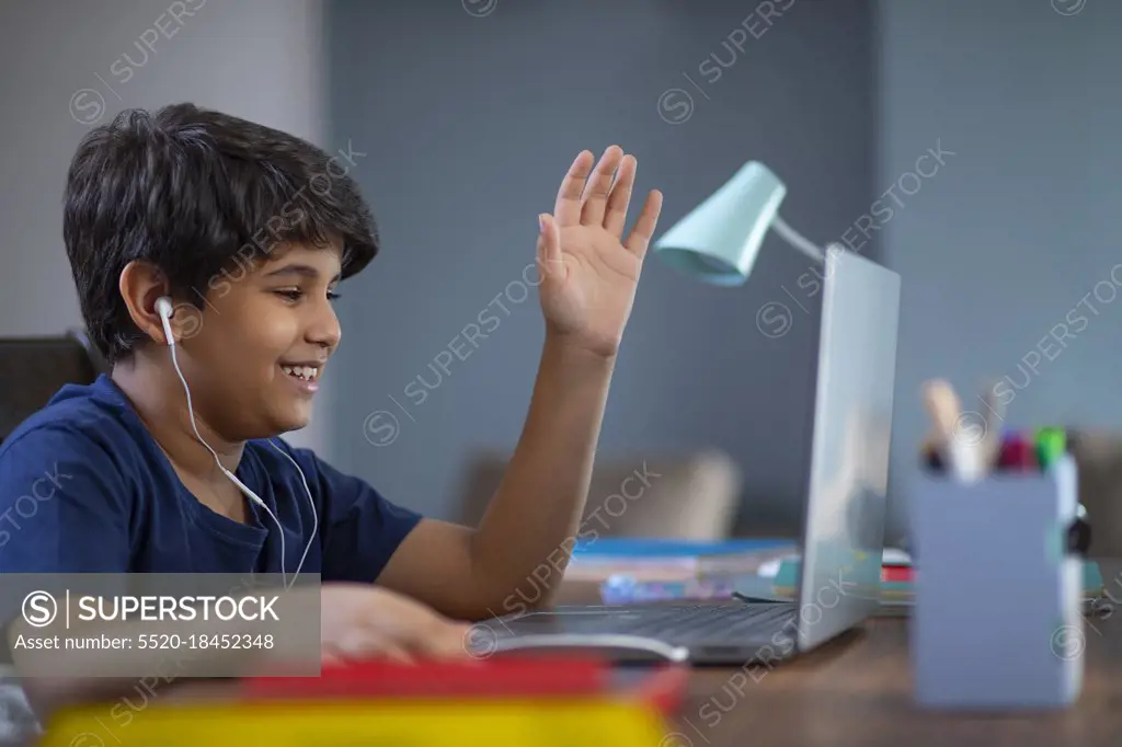 Young boy attending online class on his laptop during lockdown