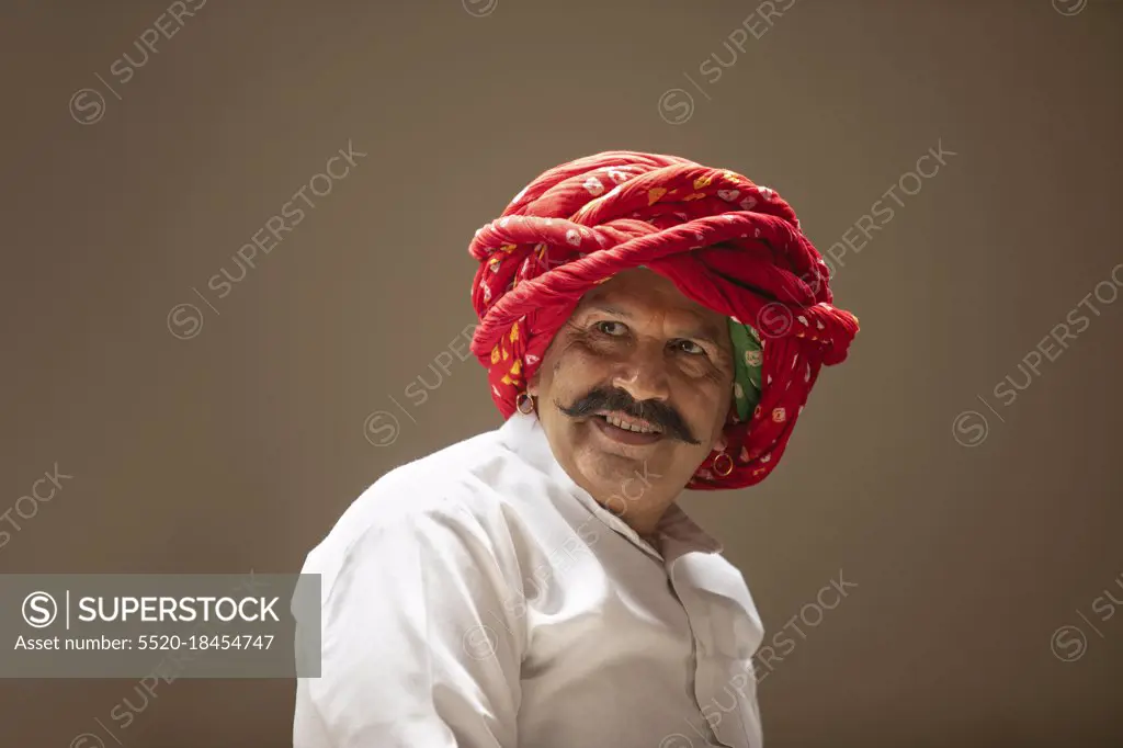 PORTRAIT OF A TURBANED VILLAGER HAPPILY LOOKING AWAY