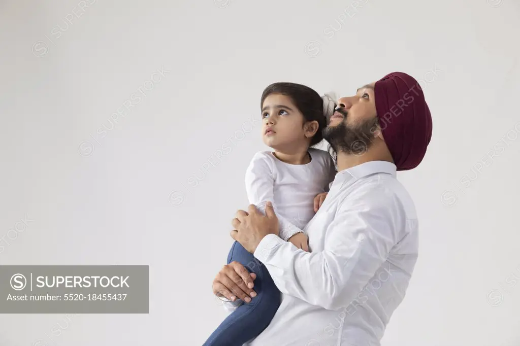 A SIKH FATHER AND DAUGHTER LOOKING ON TOP