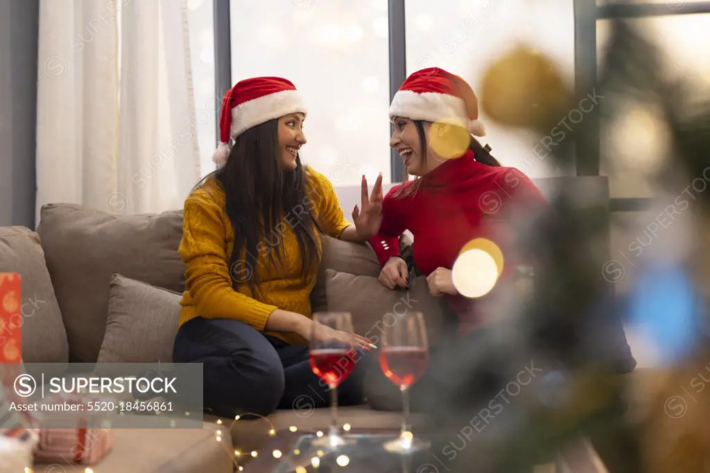 young women celebrating Christmas wine party at home