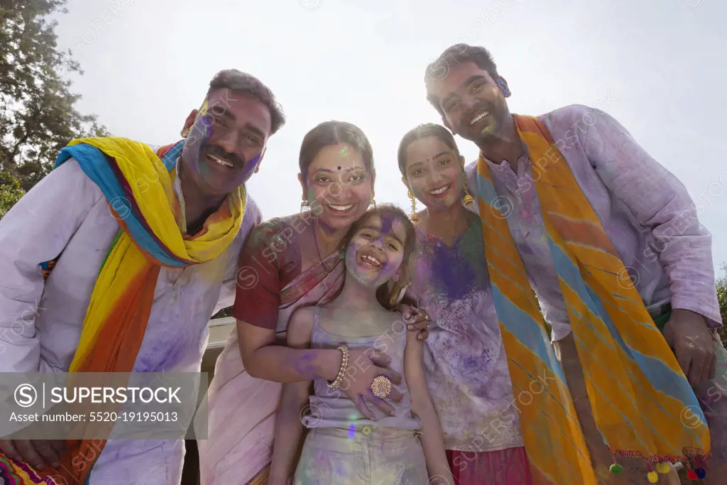 Indian family celebrating Holi together with colour