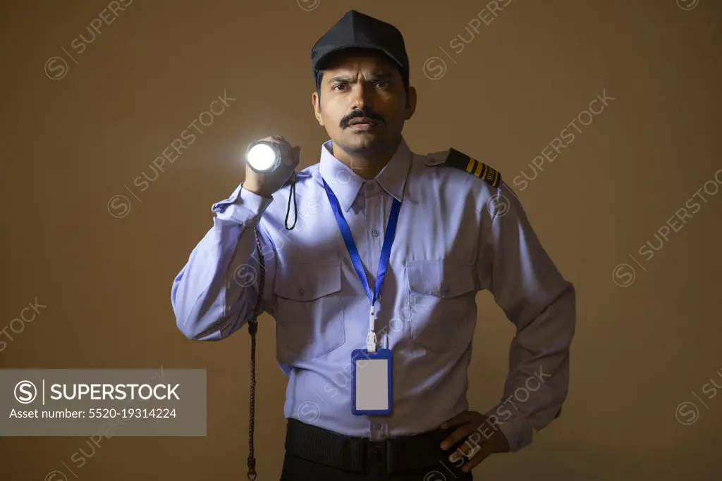 Security guard searching with torch light while working at night