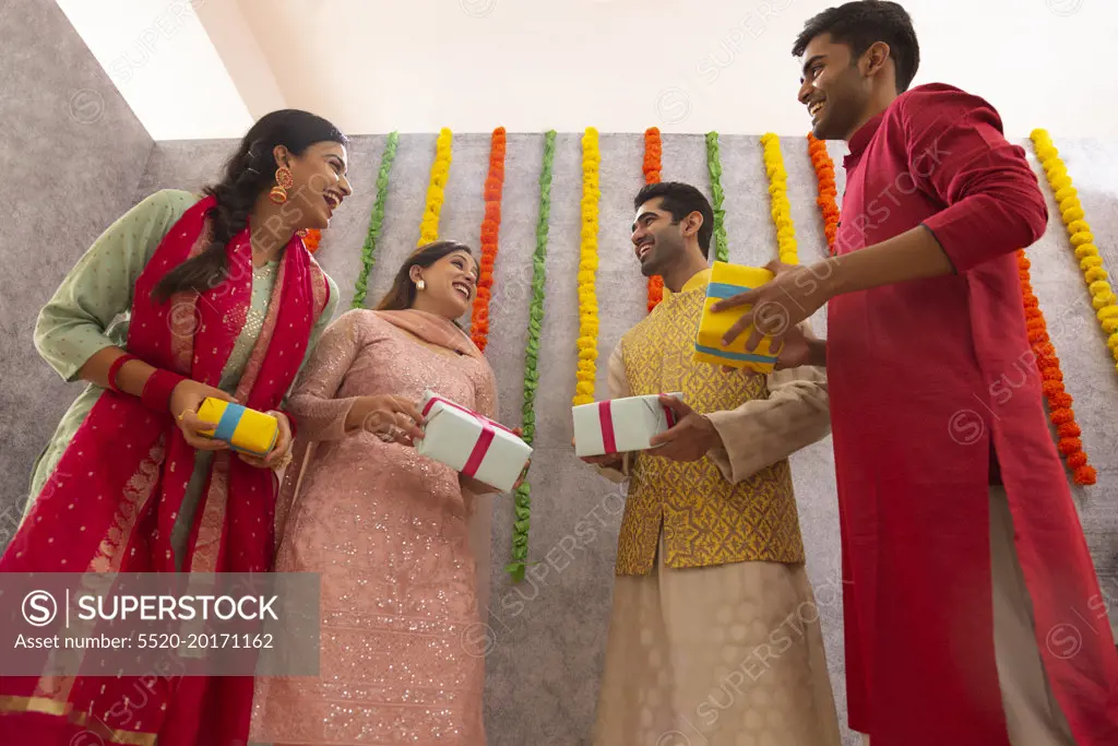 Colleagues standing together in office with gift boxes during Diwali celebration