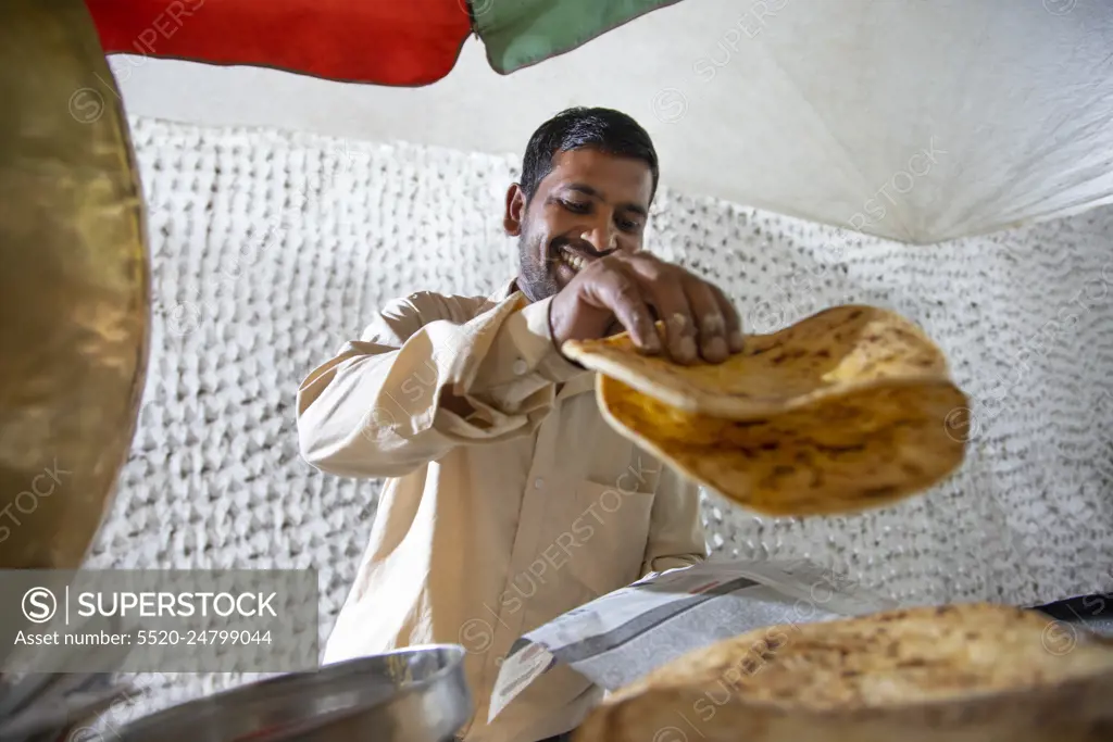 Male vendor selling paratha at his roadside food stall