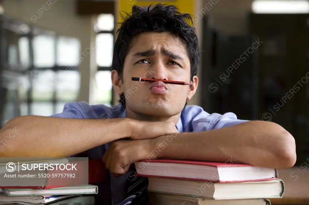 Boy balancing a pencil between his nose and mouth