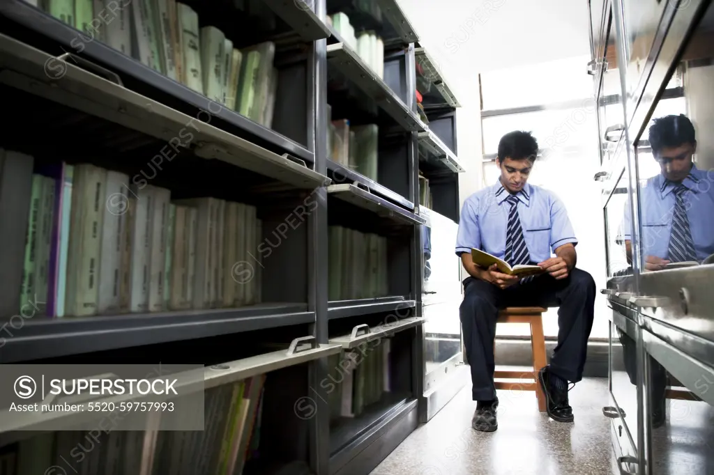 Boy reading a book in a school library