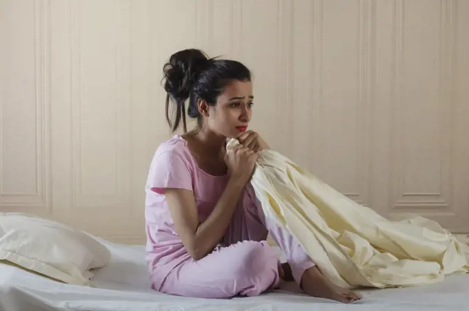 Young girl sitting alone in distress