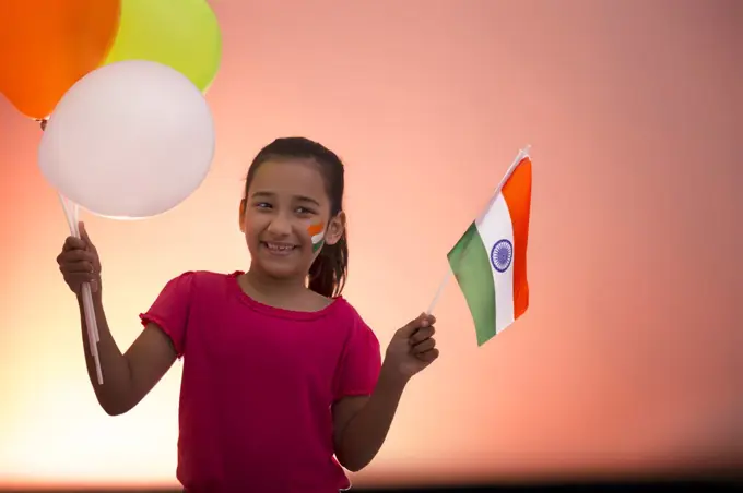 young girl holding flag and balloons, independence day