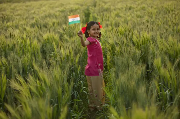 Portrait of a happy little girl holding an Indian flag