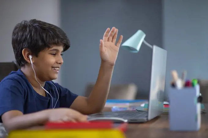 Young boy attending online class on his laptop during lockdown