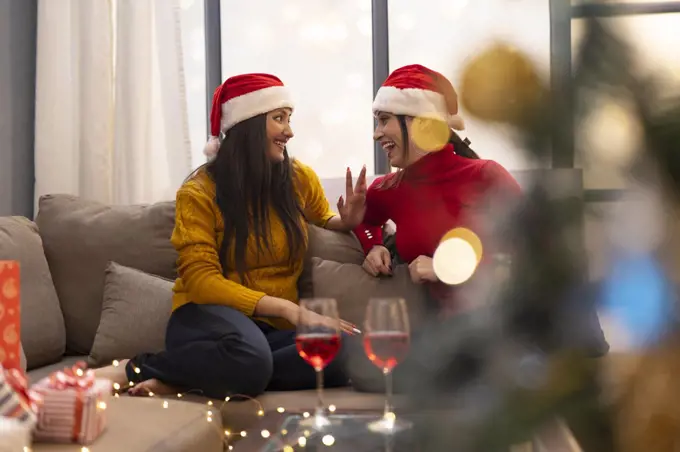 young women celebrating Christmas wine party at home