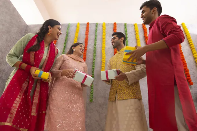 Colleagues standing together in office with gift boxes during Diwali celebration