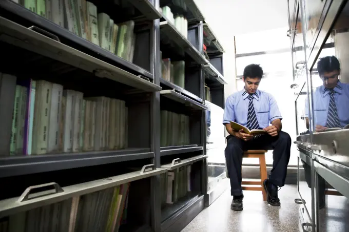 Boy reading a book in a school library