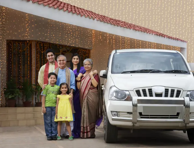 Portrait of a family standing with their car