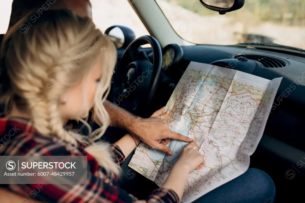 traveling by car of a young couple of a guy and a girl in plaid shirts