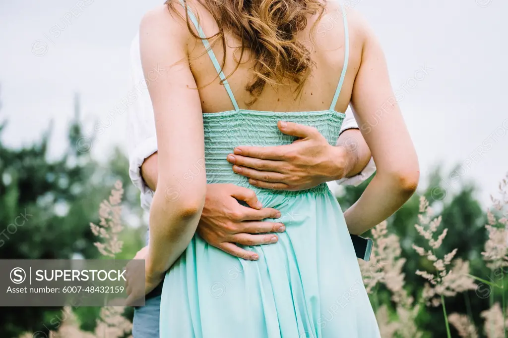 happy guy in a white shirt and a girl in a turquoise dress, the bride and groom are walking in the forest park