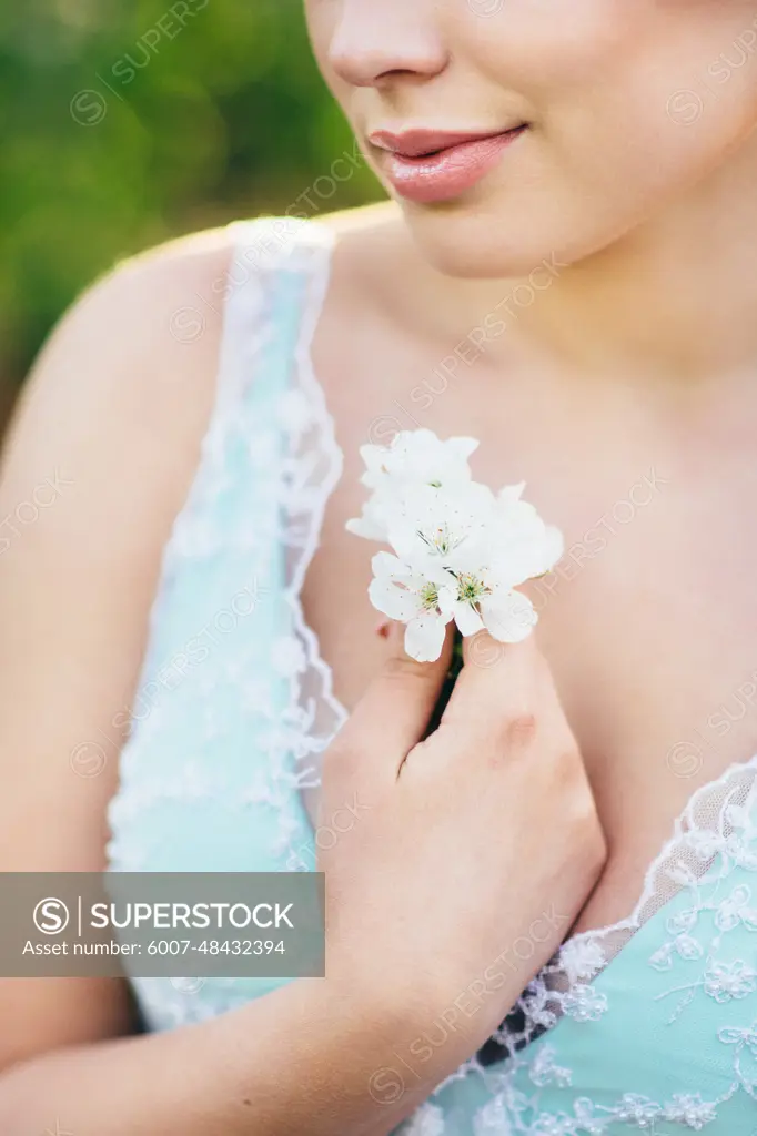 brunette girl in a turquoise dress walking in the spring garden