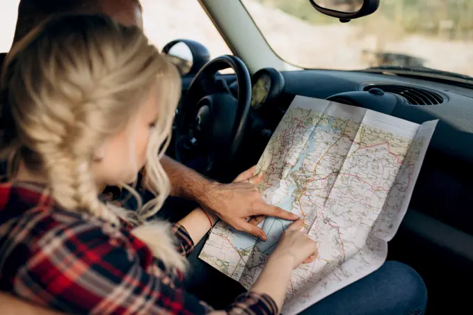 traveling by car of a young couple of a guy and a girl in plaid shirts