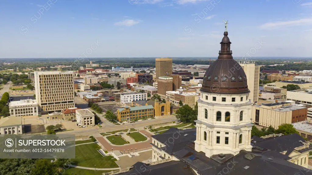 The copper dome shines in the urban area at the capitol building of Topeka Kansas