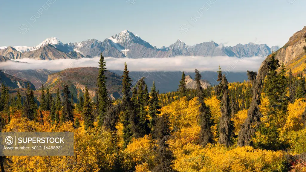 Mountains in the Chugach Range stand above the clouds rising from the Valley in Alaska North America