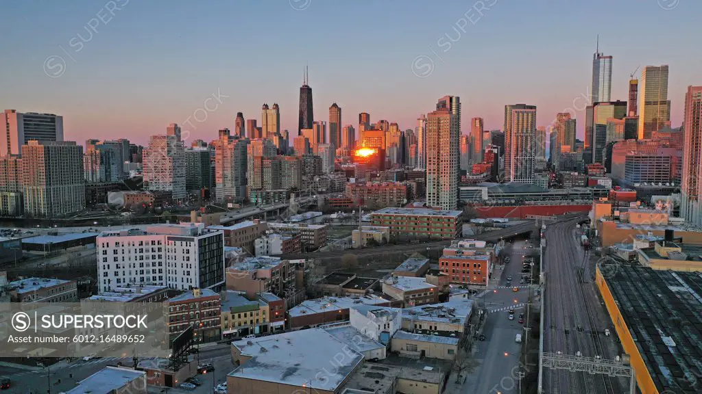 Bright orange light reflects off the buildings in downtown Chicago at sunset