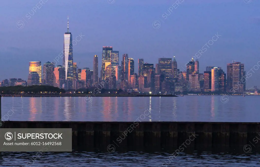 Dusk light reflects off the buildings onto Hudson Bay at sunset in Manhattan