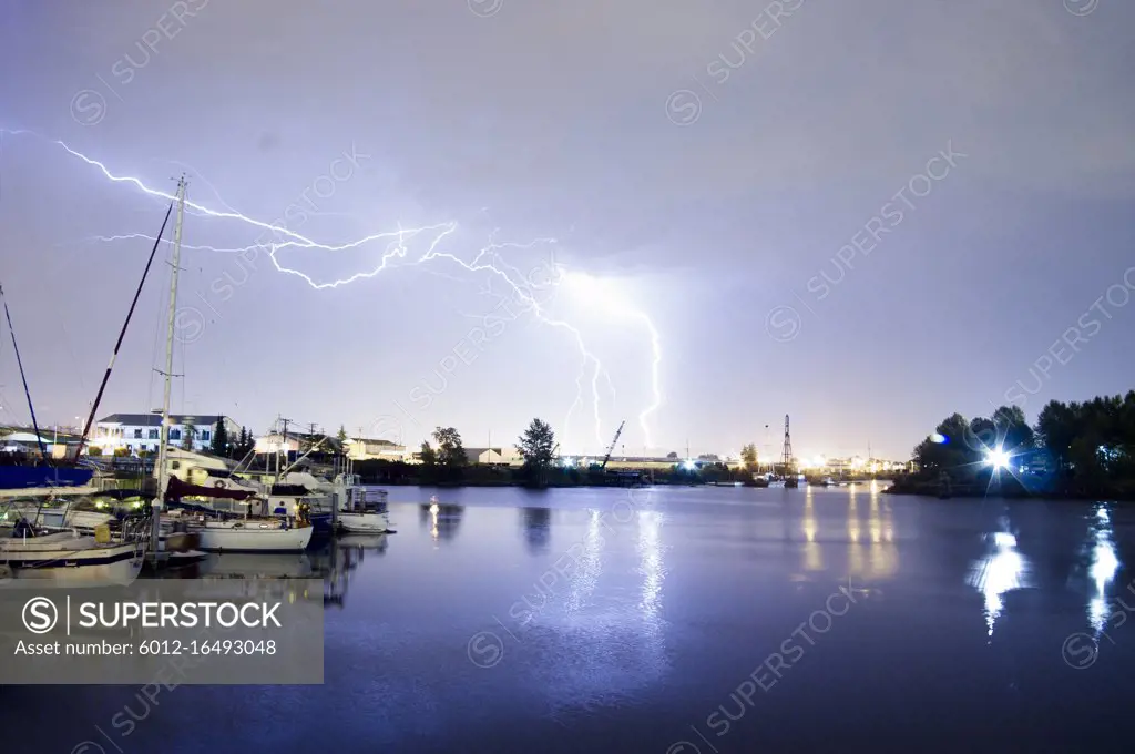 Lightning strikes over the water and marina in Tacoma