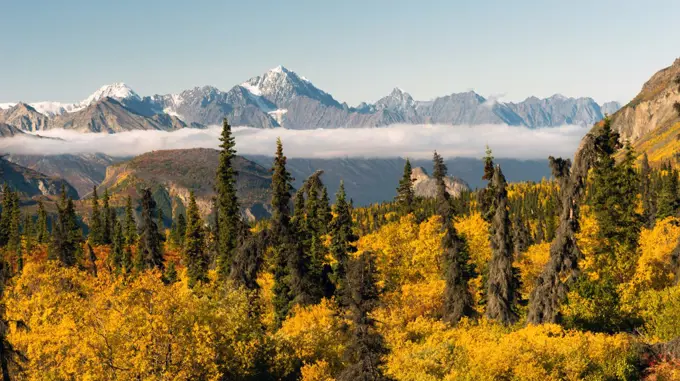 Mountains in the Chugach Range stand above the clouds rising from the Valley in Alaska North America