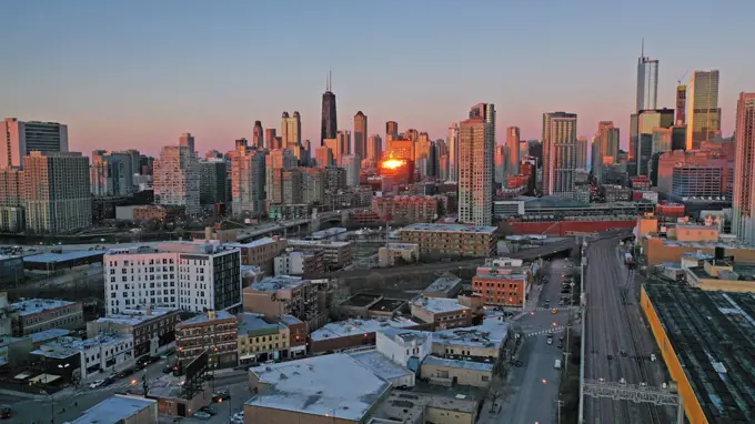 Bright orange light reflects off the buildings in downtown Chicago at sunset