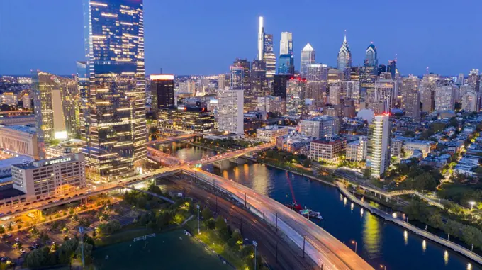 The city pumps out vibrant colorful light along the river in Philadelphia USA