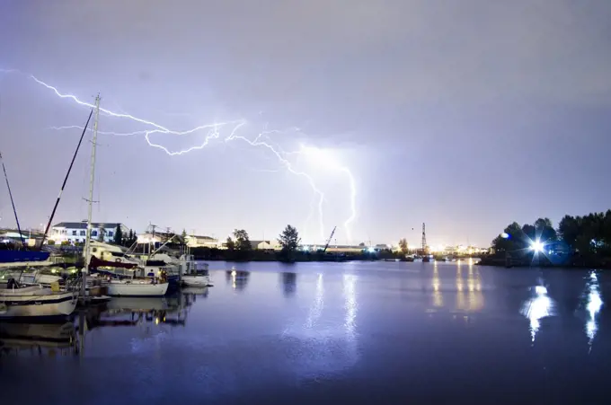 Lightning strikes over the water and marina in Tacoma