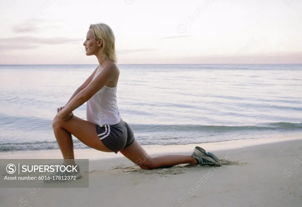 Young woman stretching on tropical beach