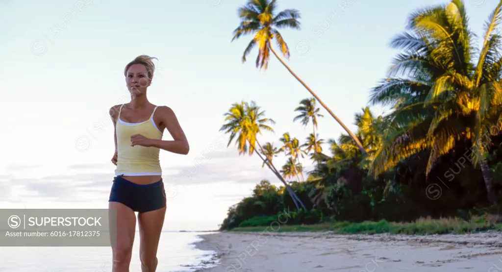 Young woman running on tropical beach