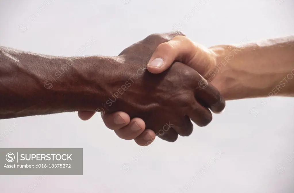 Close up of male black hand and white hand shaking