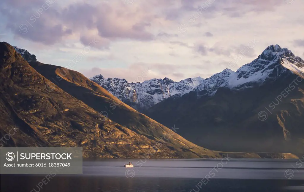 Steam boat on Lake Wakatipu and snow capped mountain range behind - New Zealand